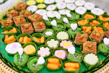 Beautiful and appetizing traditional Thai desserts including crispy curry puffs, sweet treats and jelly desserts on dessert table