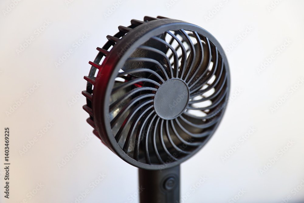Poster a small fan sits on top of a table, ready to circulate the air.