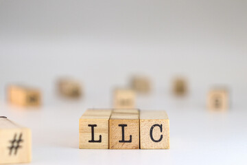 Limited Liability Company abbreviation. LLC on cubes in front view concept of business structure or tax flexibility