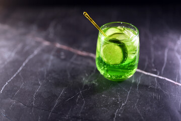 Mojito cocktail with lime wedges and ice on black background