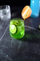 Mojito cocktail with lime wedges and ice on black background