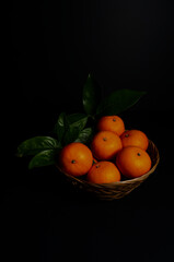 Fresh mandarins stand out vividly against a black background, highlighting their rich color and natural glow, packed with vitamin C to support immune health and overall wellness.