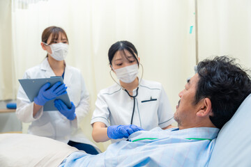 Fototapeta premium 病棟で入院患者のバイタルチェックをする看護師の女性