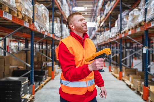 Warehouse worker scanning packages using barcode scanner, managing inventory and logistics in a distribution center
