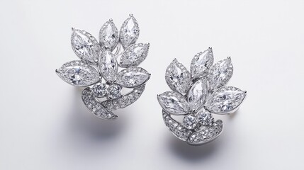 Fototapeta premium Chic white gold earrings with brilliant diamonds, displayed against a white surface to highlight their shine