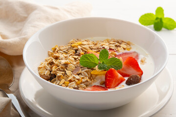 muesli with fresh strawberries and yoghurt in white bowl.delicious healthy breakfast.