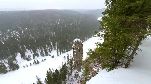View of the snowy Usvinsky pillars and the river in winter. View of the icy river Usva in winter, flowing through a rocky area in the Perm region, stone pillars. Russia 4K