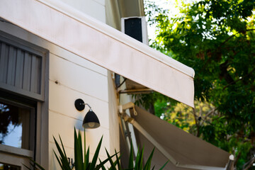 A bright, white awning is elegantly hanging from the side of a building, providing shade and adding to its appealing aesthetic