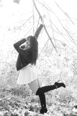 Close-up portrait of a fantastic young model girl posing in the park on a sunny day. Black and white photo.