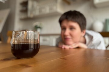 coffee mug close up and woman looking at it