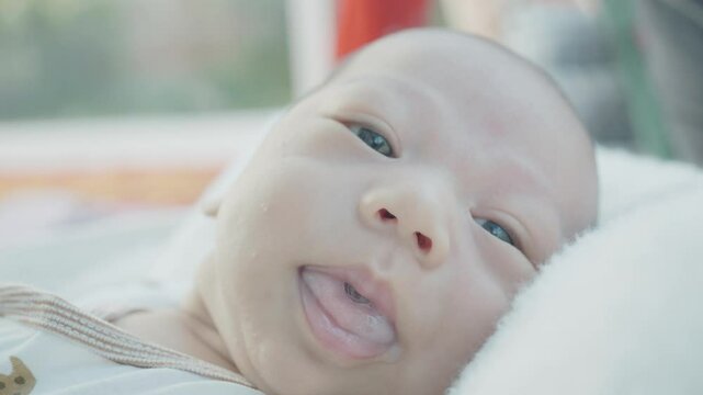 A charming close-up of a baby's face, showcasing delicate features and a curious gaze. The image captures the innocence and wonder of early life, making it perfect for family-oriented content or paren