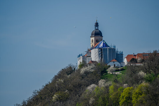 Eine Kirche thront auf einem bewaldeten H&uuml;gel