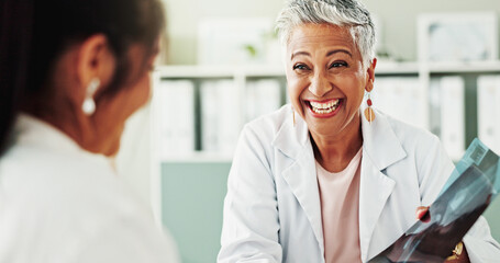 Obraz premium Appointment, women and doctor with xray, healthcare and smile for diagnosis in hospital or checkup. Clinic, medical professional and mature person with information for consultation, happy and talking