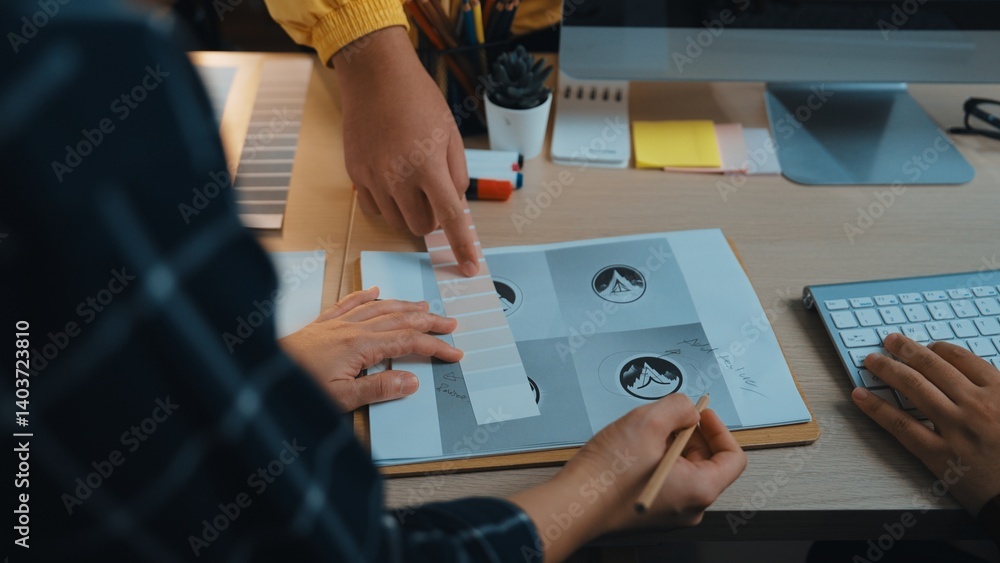 Poster a detailed view of a collaborative design session in a modern office. hands engage with sketches and