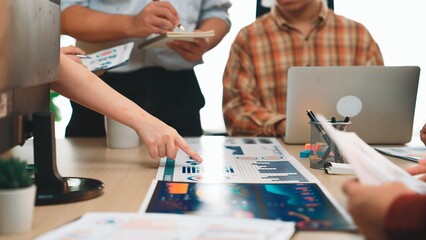 A diverse team engages in a detailed analysis of various data charts, using laptops and notepads in a modern office, highlighting collaborative business strategies. SACTR