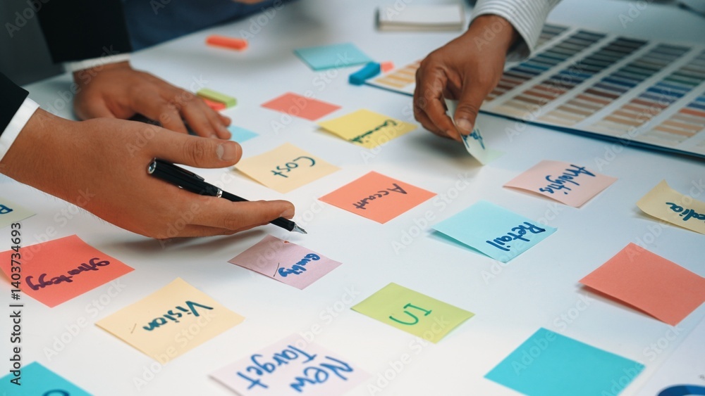 Poster engaging brainstorming session featuring diverse hands working with colorful sticky notes and a colo