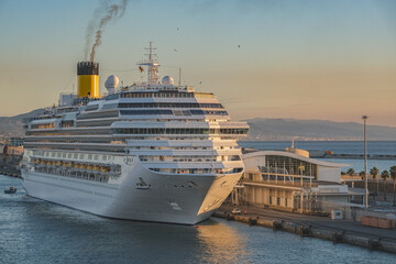 Mega family cruiseship cruise ship liner Favolosa docked at terminal in Barcelona, Spain during breathtaking sunset sunrise twilight blue hour dusk dawn silhouette scenic panorama