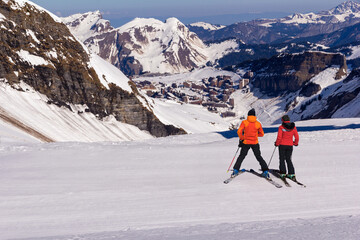 Couple of skiers admire the view of Avoriaz on a sunny day at the top of the skiing run
