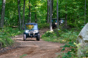 ATV, riding on trail through wooded scenery, north woods all terrain vehicle, UTV