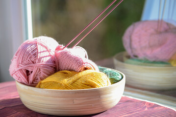A Cozy Yarn Bowl accompanied by Knitting Needles and vibrant Colorful Yarn to enjoy crafting