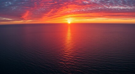 Obraz premium Fiery Sunset Over Calm Ocean Waters - Serene sunset, vibrant colors, ocean tranquility, fiery sky, peaceful horizon. Symbolizing peace, hope, beauty, end of day, new beginnings