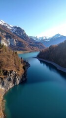 Stunning Aerial View of Turquoise Lake Surrounded by Lush Mountains and Charming Villages in a Serene Alpine Setting