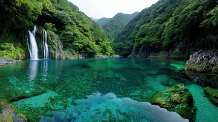 Naklejka premium A beautiful natural waterfall cascading into a vibrant turquoise lake