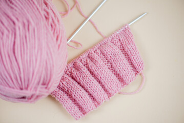 This is a delightful and cozy pink knitting project using yarn and needles for crafters