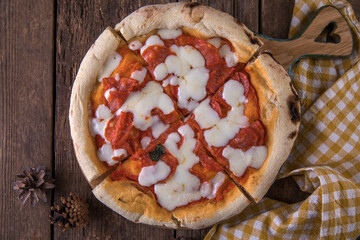 Neapolitan pepperoni pizza on wooden table