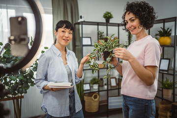 two woman use mobile phone for live stream about care home plants