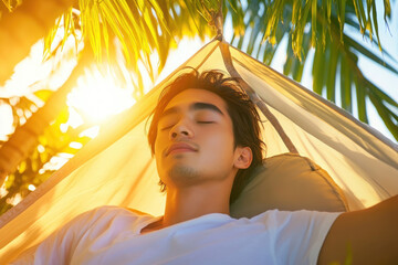A young man relaxes in a hammock, basking in the golden sunshine among palm leaves, embodying peace and tranquility.