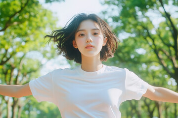 A young woman stands in a sunlit park, enjoying nature with open arms, symbolizing freedom and serenity amidst greenery.