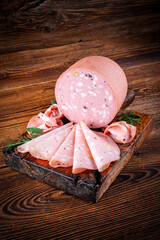 Traditional Italian artisan handcrafted fine mortadella with pistachio and truffle offered as close-up on design black board