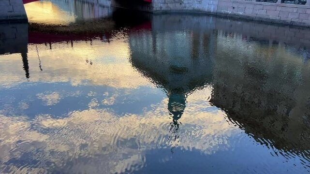 Russia, April 09, 2024: The channel in St. Petersburg in the spring. Bridges and historical buildings on the river embankment, people walking along the embankment. Reflections of houses in the water. 