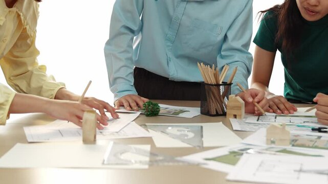 A video of architect use measurement tools and pencil to measure blueprint. Architect design house construction on a table at studio, with architectural plan scattered around. Focus hand. Delineation.