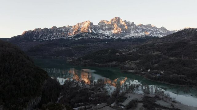 Aerial shot - Golden hour bathing Pena Telera in warm light, creating a stunning reflection on the tranquil waters of Bubal reservoir, nestled within the breathtaking Spanish Pyrenees
