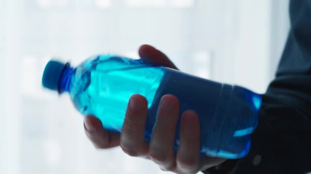 Blue plastic bottle close-up in hands.
Cool drink in a bottle.
Ungassed water in a bottle.
Half-liter bottle with water.
Container with water