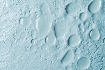 Light blue surface with water droplets.  A close-up view of a light blue textured surface, covered in various-sized water droplets. 