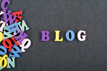 BLOG word on black board background composed from colorful abc alphabet block wooden letters, copy...