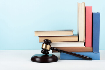Law concept open book with wooden judges gavel on table in a courtroom or law enforcement office, blue background. Copy space for text.