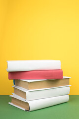 Books stacking. Open hardback books on wooden table and green background. Back to school. Copy space for ad text.
