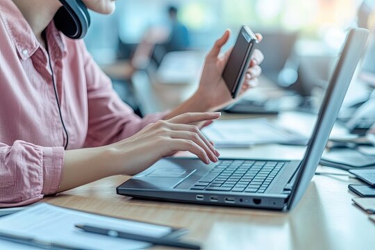 Busy worker multitasking with laptop, phone, and headset - Powered by Adobe