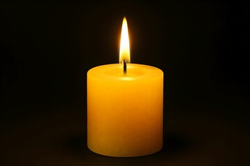 Bright yellow candle emits warm light in dark setting, creating a serene and calming atmosphere
