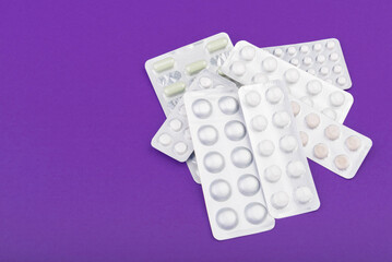 Glass thermometer between red pills and purple capsules