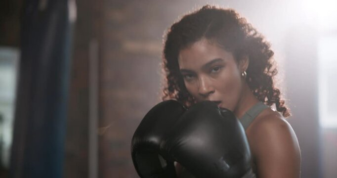 Boxing, face and girl in gym for punch, training and preparation for mma competition. Fitness center, professional and female boxer with gloves for power, energy and workout for sports challenge