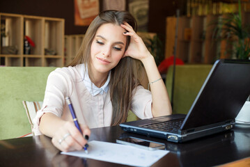 The girl in the cafe makes an entry in the diary.