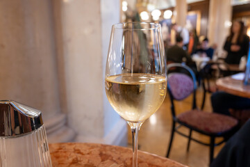 Lifestyle of beautiful Vienna, glass of cold white dry Austrian wine served in old Viennese-style cafe in Vienna, Austria