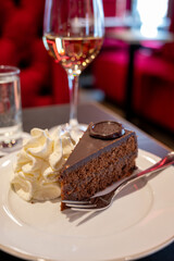 Piece of famous Sachertorte chocolate cake with apricot jam of Austrian origin served with whipped...