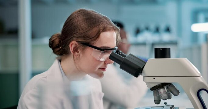 Woman, scientist and forensic with microscope for research, new discovery or examination at laboratory. Female person or biologist looking through scope for science, dna test or chemistry at lab