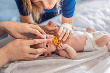 A newborn baby receives gentle osteopathic care, lying calmly while the specialist carefully examines and adjusts the infant. A moment of professional pediatric care, early development, and holistic